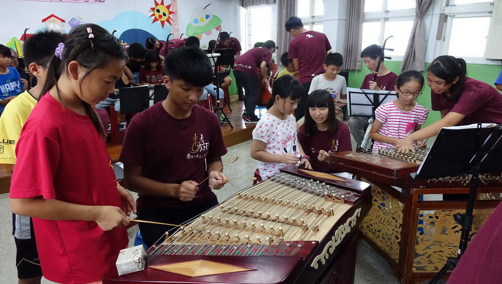 嘉義高工國樂社學生指導七美國小參與活動的小朋友練習樂器