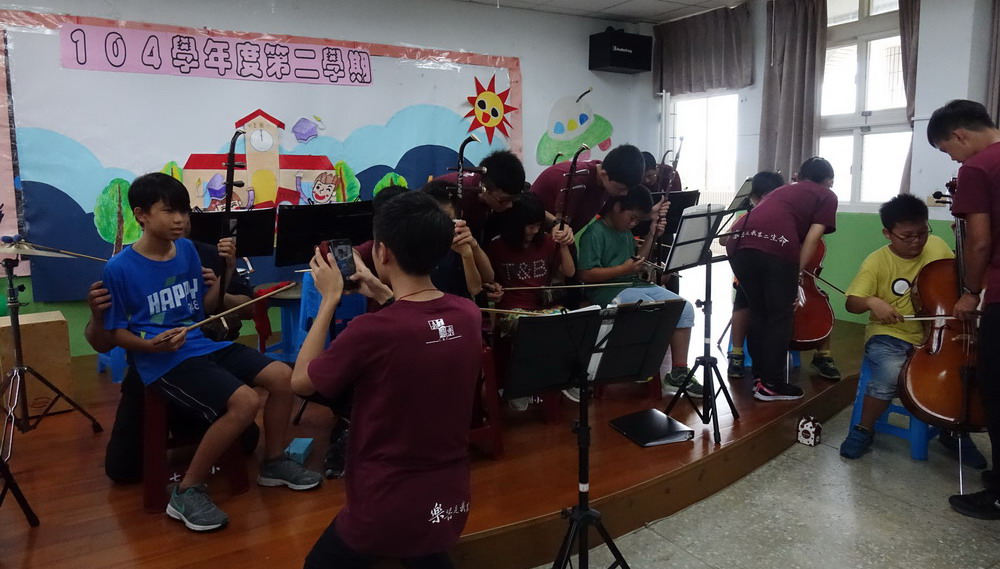 嘉義高工國樂社學生指導七美國小參與活動的小朋友練習樂器