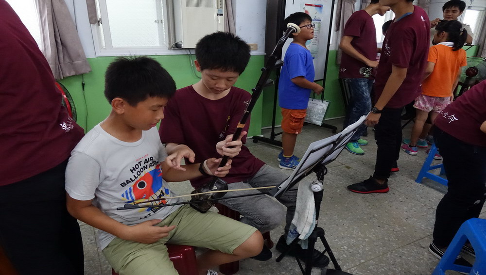 嘉義高工國樂社學生指導七美國小參與活動的小朋友練習樂器