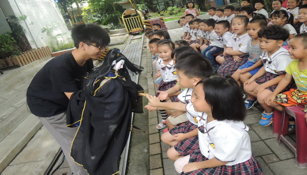 演出後操偶的大哥哥們拿著戲偶與小朋友們互動