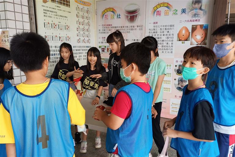 關主們細心地引導闖關孩子體驗打竹板