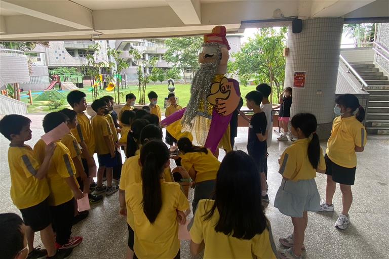 孩子排隊體驗舉神偶來跳舞的活動