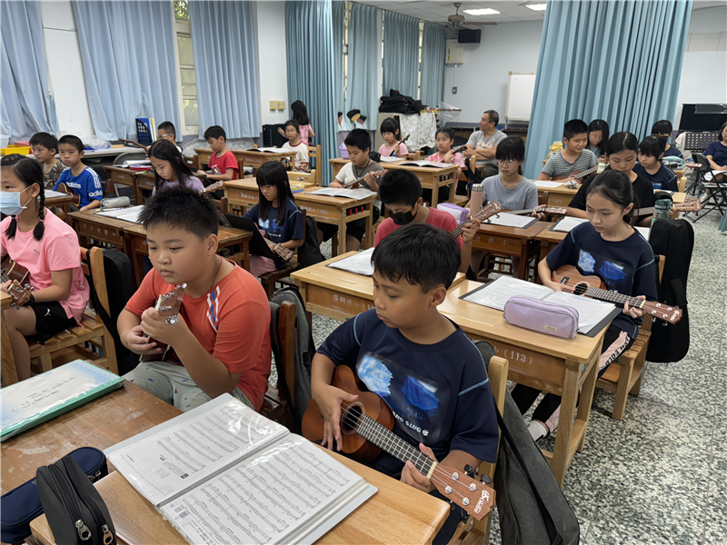 小朋友在師長的指導下，認真練彈烏克麗麗