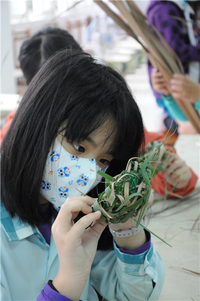 學生利用校園植物，進行編織創意造型。