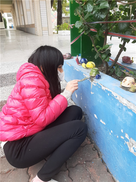 學生將製作的陶藝蝸牛鑲嵌在學校廊道
