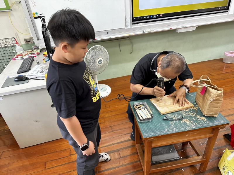 藝術家指導學生木雕技巧