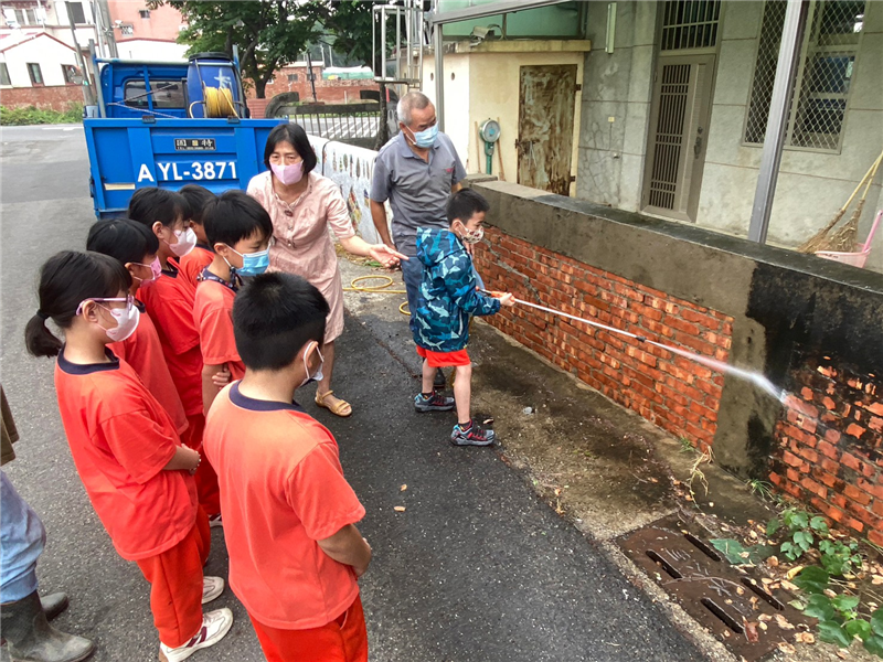 低年級學生黏貼陶板前置作業清洗牆壁
