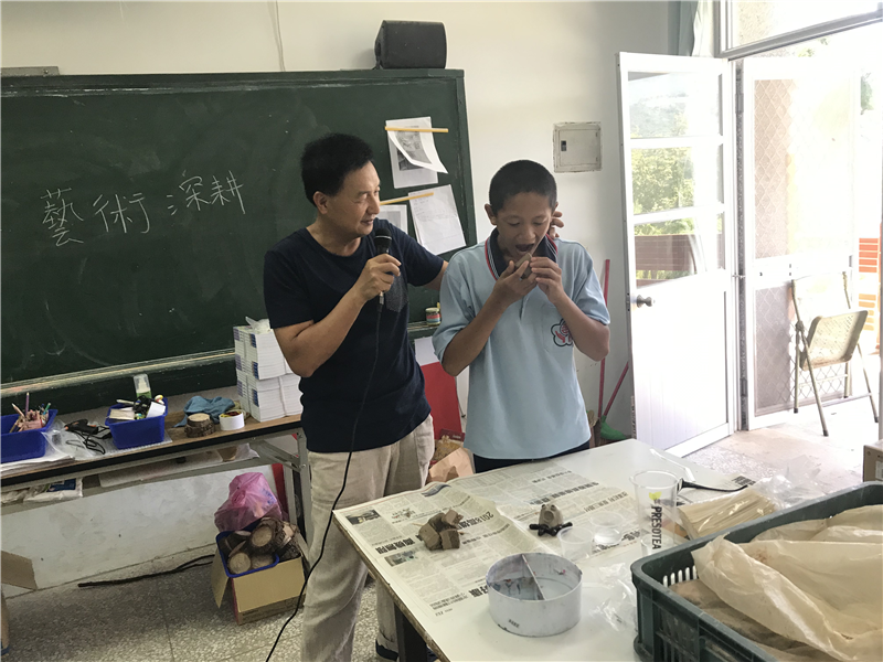 老師講解與學生的示範來讓其他學生了解陶土的操作特性。