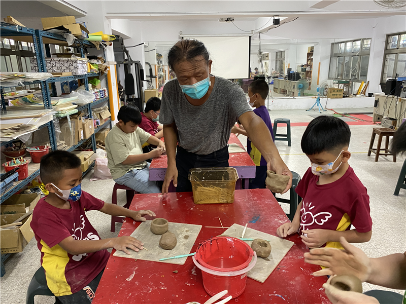 學生聆聽完教學後，嘗試進行陶板成型的創作