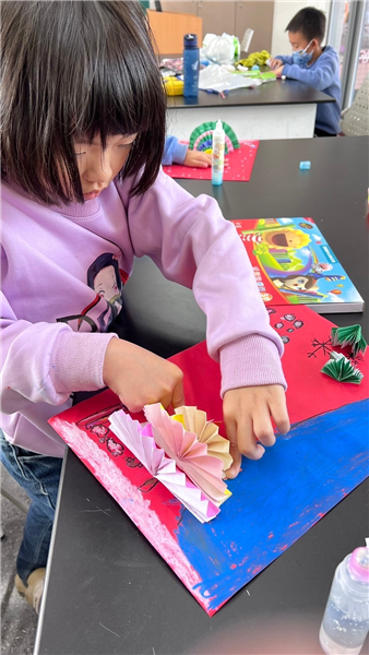 教師引導學生摺紙之手部肌練訓練，摺出精緻之彩色耶誕樹立體作品。課程主題名稱—「彩色耶誕樹」。
