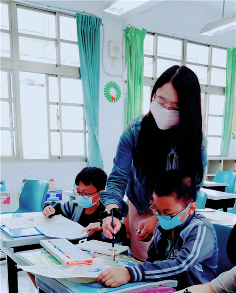 老師指導學生彩繪作品