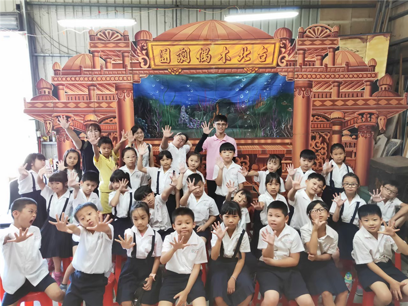 學生至劇團參加戶外教學活動，於戲台前合影